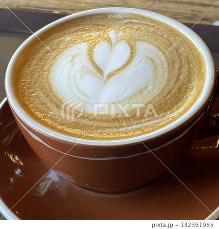 A beautifully crafted latte, featuring creamy foam art on top of rich espresso. Perfect for coffee-related projects, this image captures the warmth and inviting nature of a classic café experience. 132361985