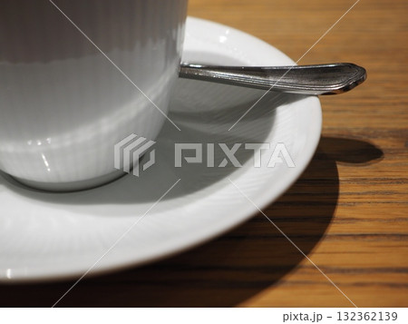 木漏れ日差すカフェのテーブル_白磁のカップとスプーンが誘うひととき 木漏れ日差すカフェのテーブル_白磁のカップとスプーンが誘うひととき 132362139