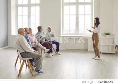 Group of senior men and women listening to lecture by psychologist or business coach 132362231