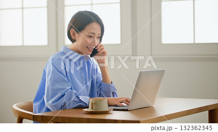 パソコンをする女性(電話) 132362345