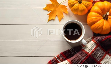 Autumn-inspired image of a coffee cup and pumpkin on a white wooden table, surrounded by rich, colorful maple leaves Autumn-inspired image of a coffee cup and pumpkin on a white wooden table, surrounded by rich, colorful maple leaves 132363605