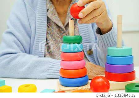 Asian elderly woman playing enhancing skill board game. 132364518