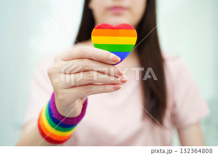 Asian woman holding LGBT heart with rainbow flag. 132364808