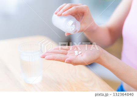 ビューティーイメージ　サプリメントを手に取る女性の手元元 132364840