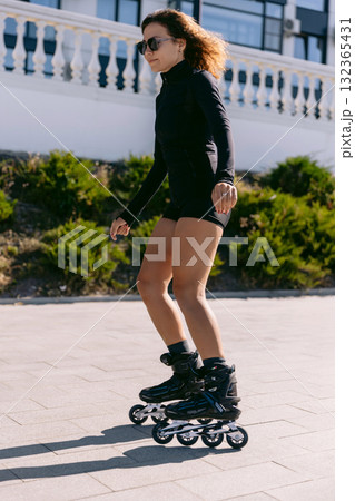 Sporty woman rollerblading outdoors in black sport wear, active lifestyle and fitness Sporty woman rollerblading outdoors in black sport wear, active lifestyle and fitness 132365431