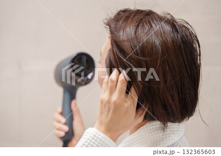 風呂上がりにドライヤーをする女性 風呂上がりにドライヤーをする女性 132365603