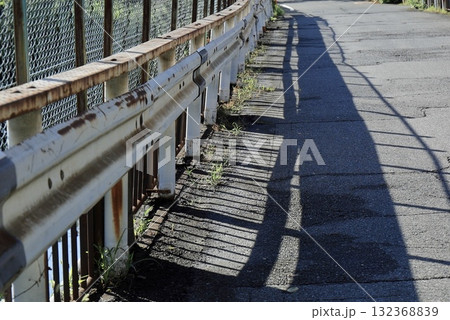 歪んだ道路とガードレールの影 132368839