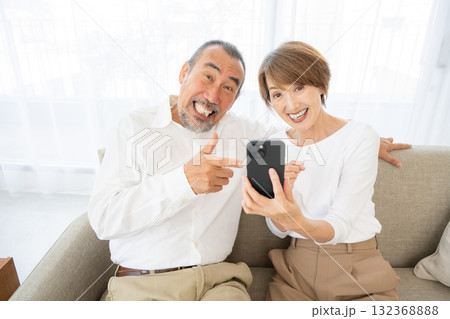 スマホを見て驚くシニア夫婦 132368888