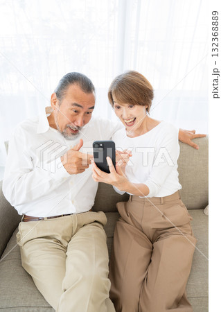 スマホを見て驚くシニア夫婦 スマホを見て驚くシニア夫婦 132368889