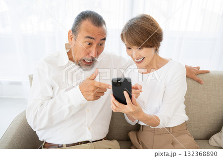 スマホを見て驚くシニア夫婦 132368890