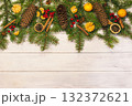 spruce branches with cones on a wooden light background decorated with tangerine 132372621