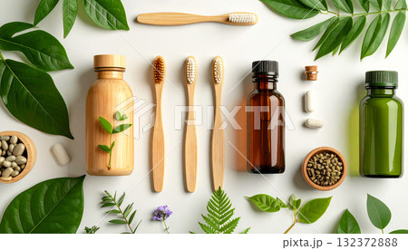 Flat lay of eco-friendly hygiene products on soft peach background, featuring liquid soap bottles, solid soaps, bamboo toothbrushes, brushes, and tropical green leaves, clean and refreshing aesthetic 132372888