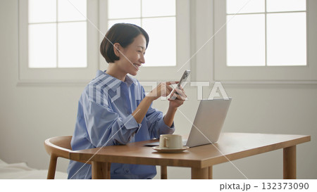 パソコンをする女性(携帯操作) 132373090