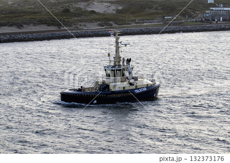 Tugboat Cruising Through Calm Waters Near the Coastline Tugboat Cruising Through Calm Waters Near the Coastline 132373176