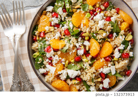 Pomegranate and Orange Quinoa Salad with added spinach, feta and crispy pistachios closeup on the plate. Horizontal top view Pomegranate and Orange Quinoa Salad with added spinach, feta and crispy pistachios closeup on the plate. Horizontal top view 132373913