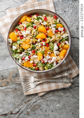 Quinoa salad with spinach, feta, tangerines, pomegranate, and pistachios, close-up in a bowl. Vertical top view Quinoa salad with spinach, feta, tangerines, pomegranate, and pistachios, close-up in a bowl. Vertical top view 132373914