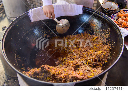 大きな釜で炊き込んでいるウズベキスタンの国民食として有名な美味しいプロフ 大きな釜で炊き込んでいるウズベキスタンの国民食として有名な美味しいプロフ 132374514