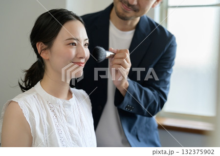 女性をメイクアップする男性 132375902