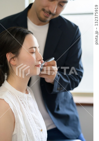 女性をメイクアップする男性 132375919