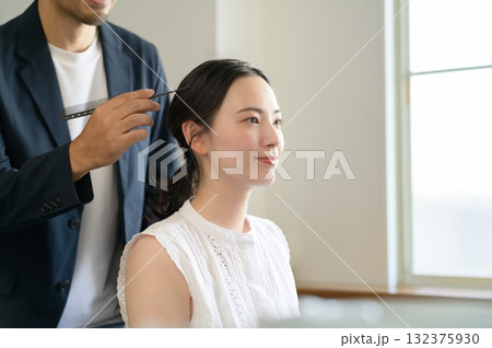 女性をメイクアップする男性 132375930