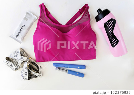 Concept of losing weight with the diabetes drug Ozempic. Sports top and Ozempic syringe pen. 132376923