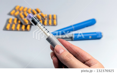 Hand holding Ozempic Insulin injection pen for diabetics and weight loss Hand holding Ozempic Insulin injection pen for diabetics and weight loss 132376925