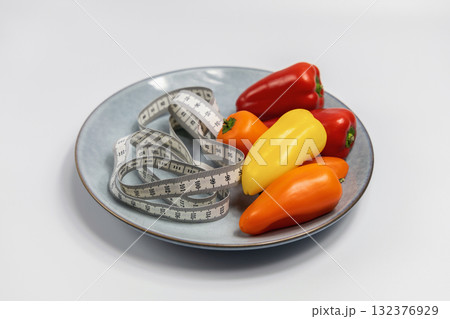Plate with sweet peppers and a measuring tape. Concept of diet and weight loss 132376929