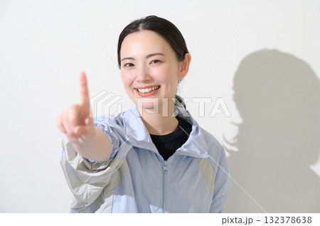 スポーツウェアを着て指をさす女性 132378638