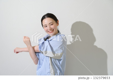 白背景でストレッチをする日本人女性 132379653