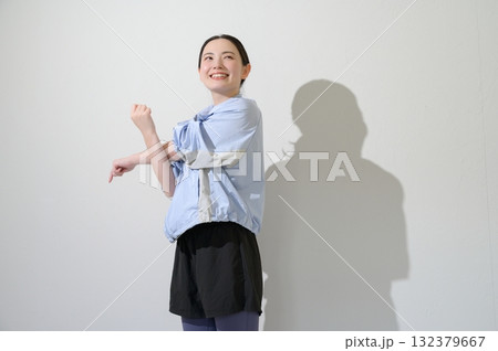 白背景でストレッチをする日本人女性 132379667
