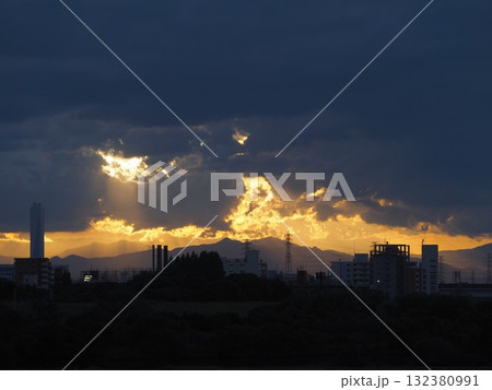 夕暮れの雲の隙間から差す薄明光線と光る関東山地 夕暮れの雲の隙間から差す薄明光線と光る関東山地 132380991