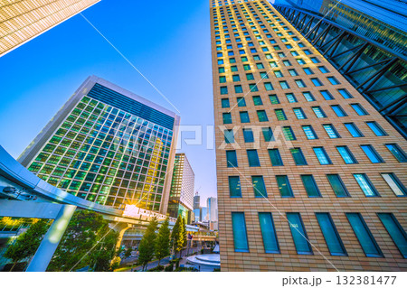 日本の東京都市景観珍景。太陽光を反射するゆりかもめや汐留駅、汐留のオフィス街を望む。新時代へ希望の光 132381477