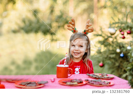 Christmas in july. Child waiting for Christmas in wood in july. portrait of little girl drinking hot cocoa with marshmallow and gingerBread man cookies. Merry Christmas and Happy Holidays. 132381760