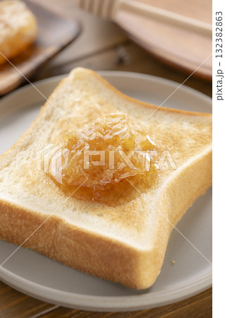 焼きたてのトーストに巣みつをのせた朝食シーン 132382863