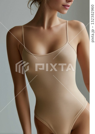Minimalist studio portrait of woman in beige bodysuit with natural lighting Minimalist studio portrait of woman in beige bodysuit with natural lighting 132382960