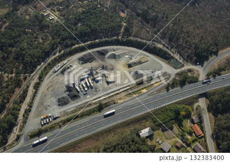 Construction site near highway with vehicles and materials in view Construction site near highway with vehicles and materials in view 132383400