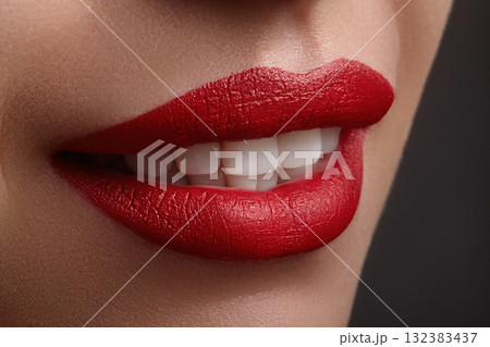 Closeup of woman bright red lips with a perfect smile, symbolizing confidence, passion, sensual beauty and elegance in fashion and makeup aesthetics. White teeth, fashion make-up 132383437