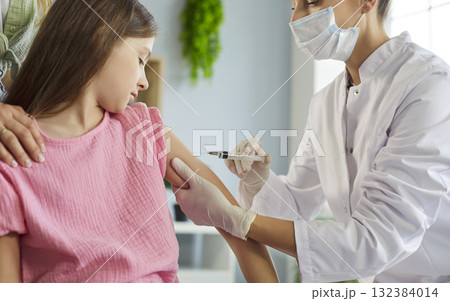 Nurse giving vaccination injection to child at clinic, pediatric safety care Nurse giving vaccination injection to child at clinic, pediatric safety care 132384014
