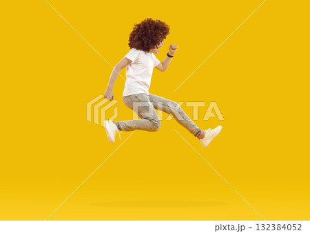 Energetic, funny, happy boy in red - haired curly wig jumps and screams. 132384052