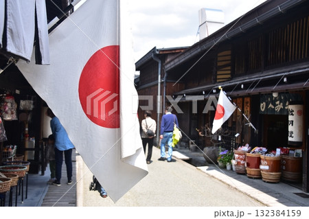 日本の岐阜県 高山市の古い町並み 春の高山祭期間中 日本国旗を掲げる店舗と買い物を楽しむ観光客 日本の岐阜県 高山市の古い町並み 春の高山祭期間中 日本国旗を掲げる店舗と買い物を楽しむ観光客 132384159