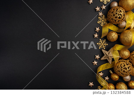 Golden Christmas Ornaments and Ribbon on Black Background 132384588