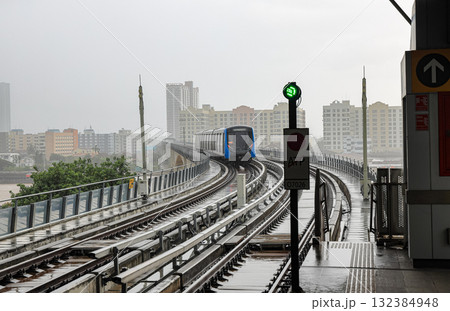 The train approached the platform to take up passengers in rainstorm. 132384948