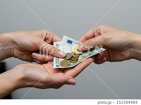 Close-up of hands exchanging euro cash and coins. A woman makes a payment to another person during a financial transaction 132384969