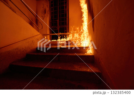 Stairway engulfed in flames, fire burning on steps and walls, dangerous situation, arson concept, emergency scene, dramatic lighting, stairway to hell, inferno, danger, risk, destruction 132385400