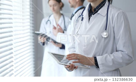 Medical professional using a digital tablet for patient care and data management, collaborating with doctors and healthcare workers in a modern clinic or hospital setting Medical professional using a digital tablet for patient care and data management, collaborating with doctors and healthcare workers in a modern clinic or hospital setting 132386630