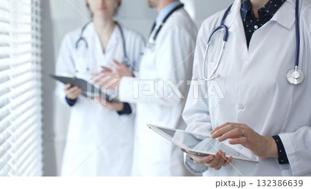 Medical professional using a digital tablet for patient care and data management, collaborating with doctors and healthcare workers in a modern clinic or hospital setting Medical professional using a digital tablet for patient care and data management, collaborating with doctors and healthcare workers in a modern clinic or hospital setting 132386639