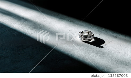 光と影の中の結婚指輪、静寂と感情を表現するミニマルな構図 132387008