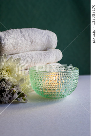 Vertical real shot of delicate spa composition ,with towels, flowers and candlelight.  132388170