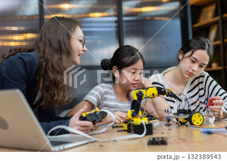 Teacher working with children engineering classroom education stem technology school. Students learning innovation electronic diy robot robot human hand. showcasing creativity and learning. Teacher working with children engineering classroom education stem technology school. Students learning innovation electronic diy robot robot human hand. showcasing creativity and learning. 132389543