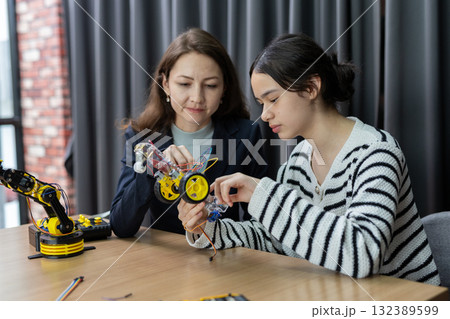 Teacher working with children engineering classroom education stem technology school. Students learning innovation electronic diy robot robot human hand. showcasing creativity and learning. Teacher working with children engineering classroom education stem technology school. Students learning innovation electronic diy robot robot human hand. showcasing creativity and learning. 132389599